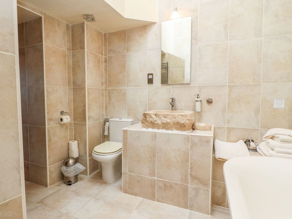 A bathroom with a sink, toilet, and bath at Shepherd's Barn in Lancaster