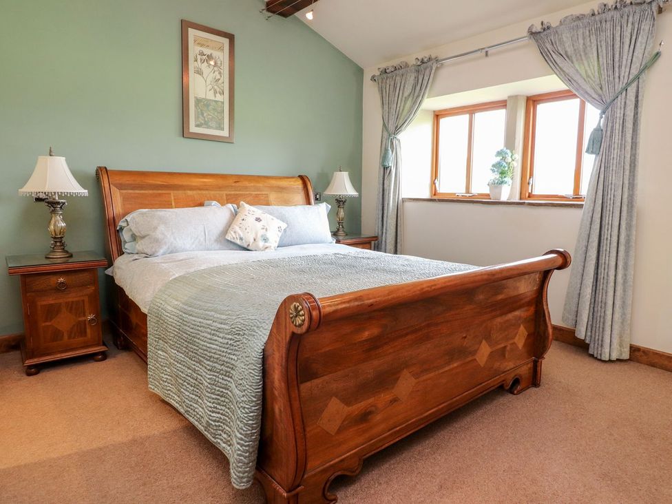 A bedroom with a wooden bed and bedside tables at Shepherd's Barn in Lancaster