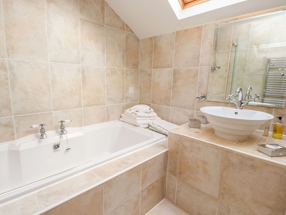 A bathroom with a bathtub and wash basin at Shepherd's Barn Lancaster