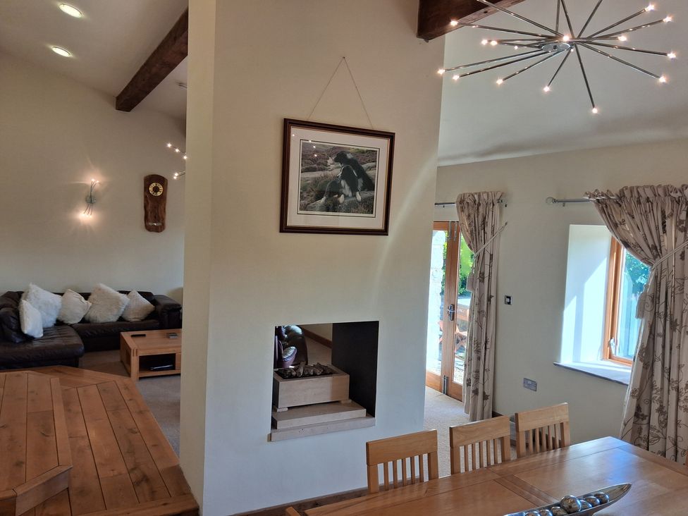 A living room with a fireplace and dining area at Shepherd's Barn in Lancaster