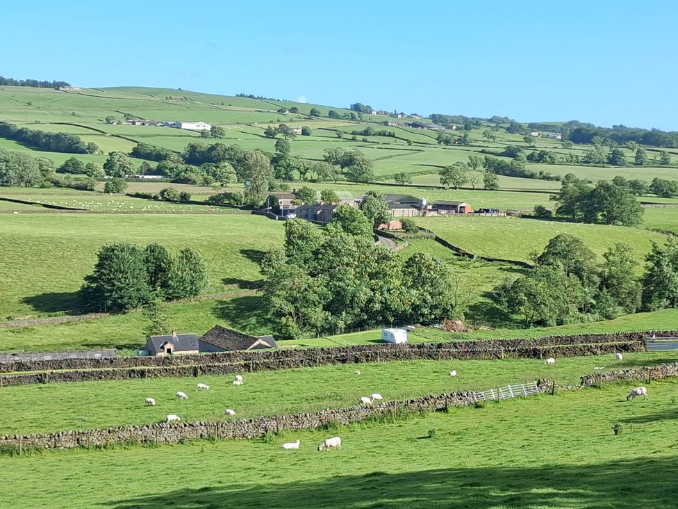 A view of sheep grazing in fields near farm buildings at Shepherd's Barn in Lancaster