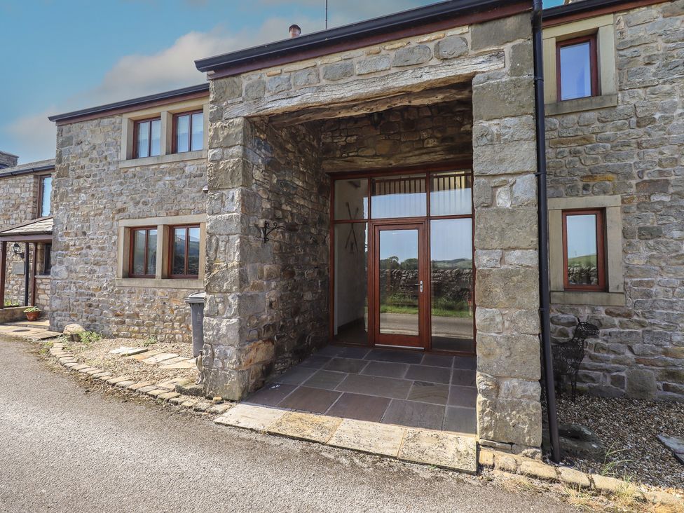 An entrance with stone walls and a wooden door at Shepherd's Barn in Lancaster