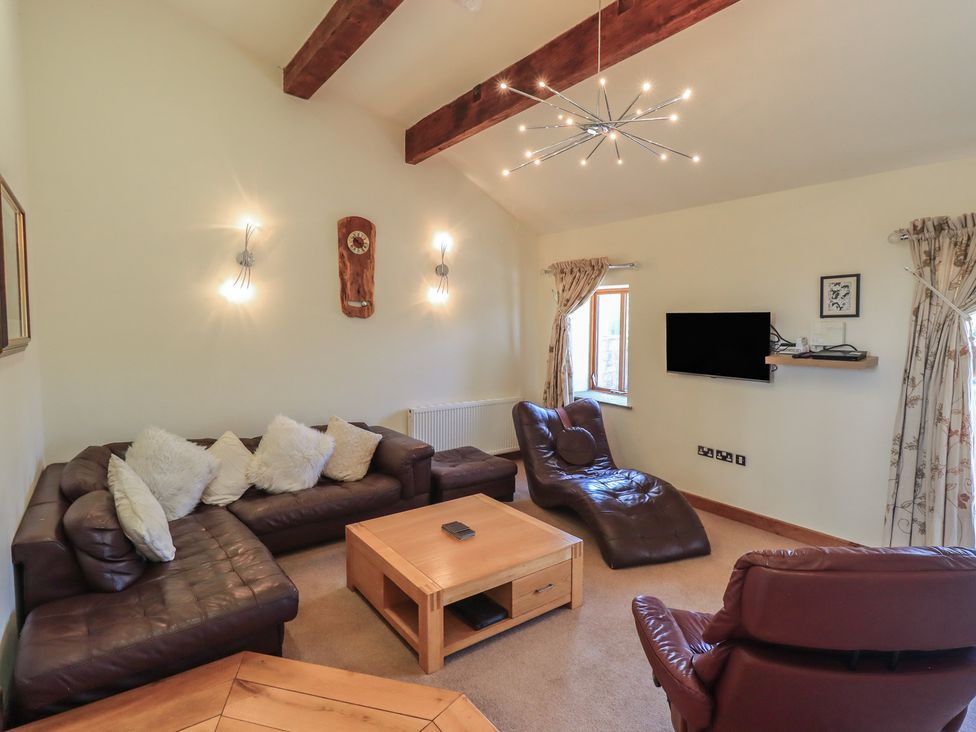 A living room with a sofa and television at Shepherd's Barn in Lancaster