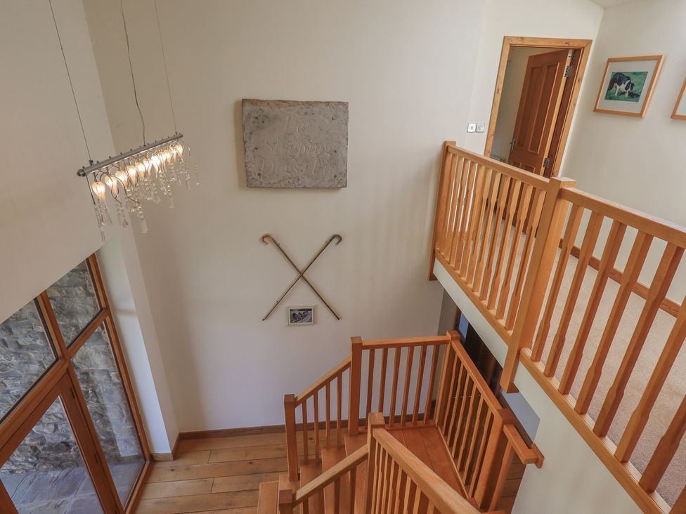 A hallway with a staircase and chandelier at Shepherd's Barn in Lancaster