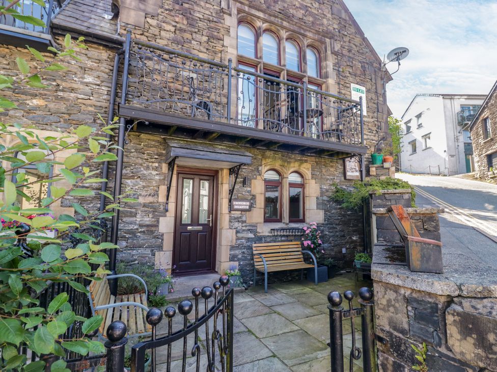 A stone building with a door and windows at Hillside Cottage in Bowness-On-Windermere