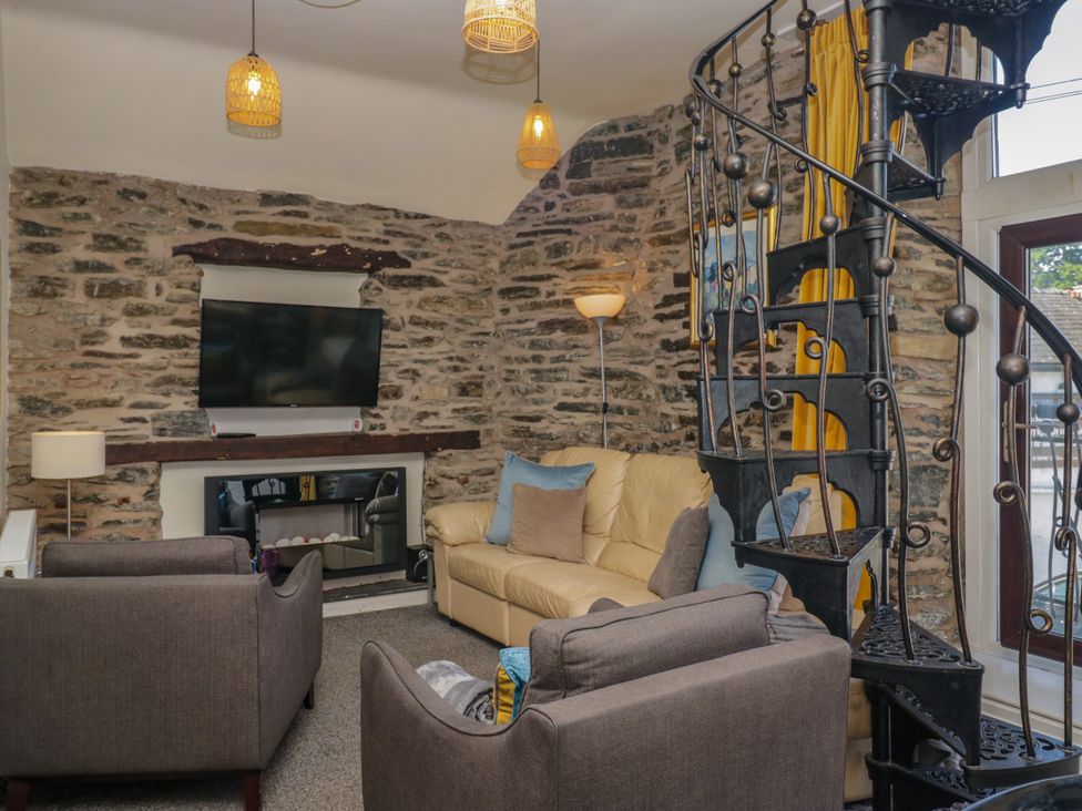 A living room with a sofa and a television at Hillside Cottage in Bowness-On-Windermere