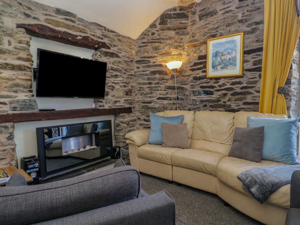 A living room with a television and a sofa at Hillside Cottage in Bowness-On-Windermere