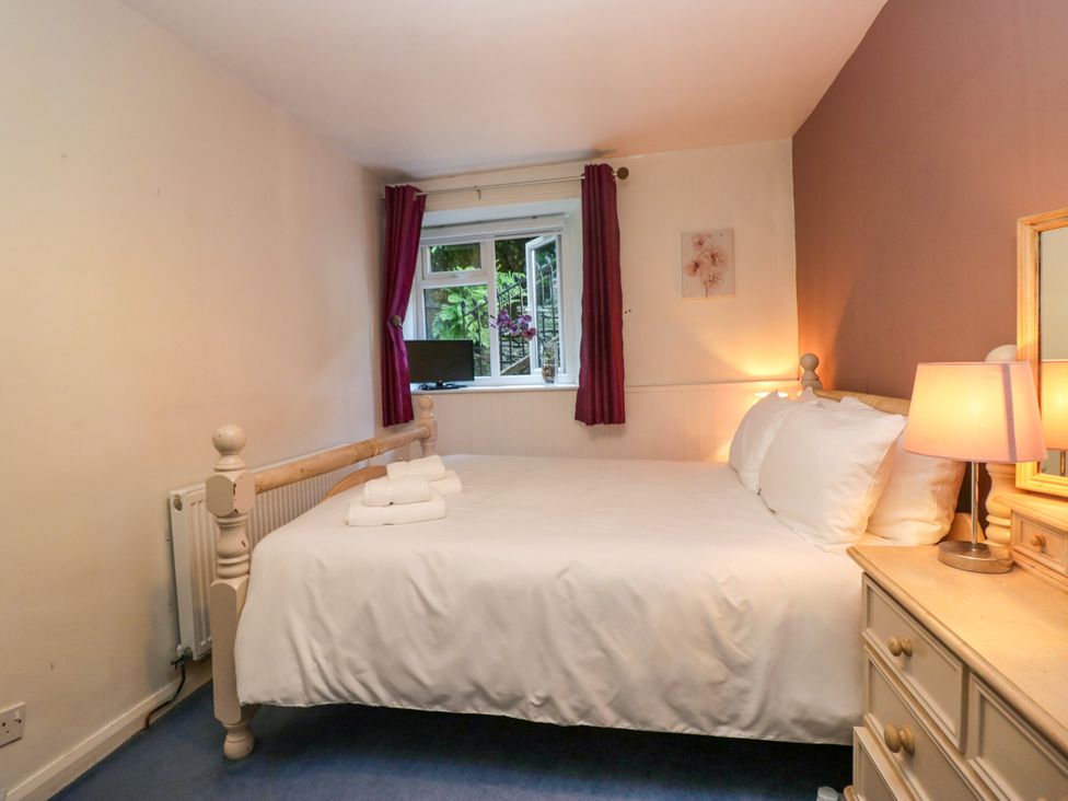 A bedroom with a bed and a window at Hillside Cottage in Bowness-On-Windermere