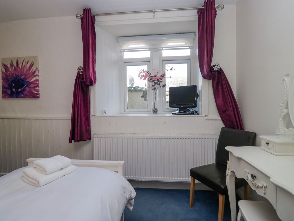 A bedroom with a bed and window at Hillside Cottage in Bowness-On-Windermere