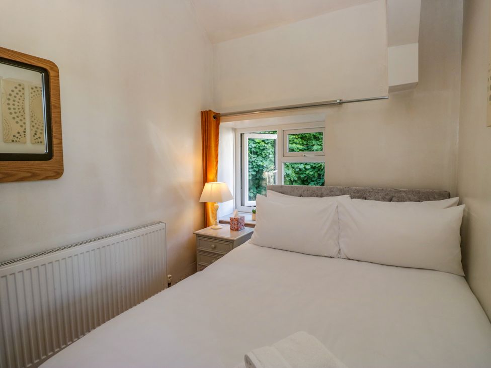 A bedroom with a bed and lamp at Hillside Cottage in Bowness-On-Windermere