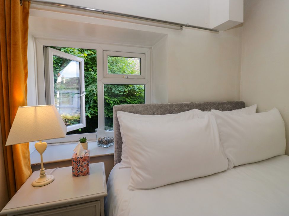 A bedroom with a bed and lamp at Hillside Cottage in Bowness-On-Windermere