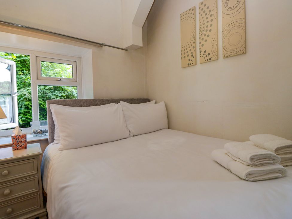 A bedroom with a bed and window at Hillside Cottage in Bowness-On-Windermere