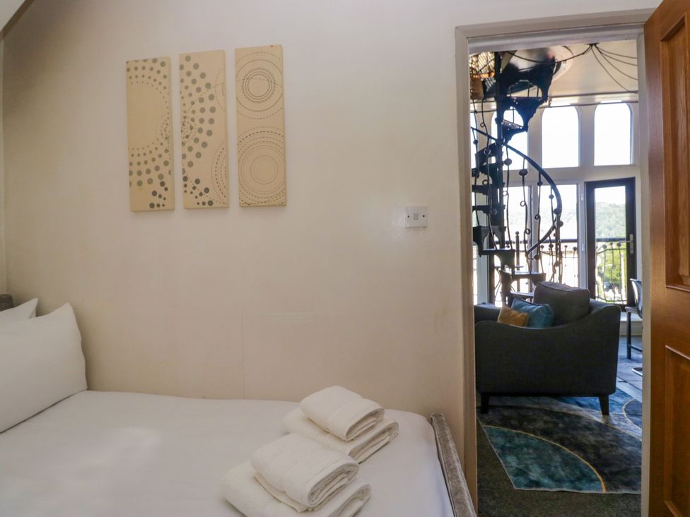 A bedroom with bed and towels at Hillside Cottage in Bowness-On-Windermere