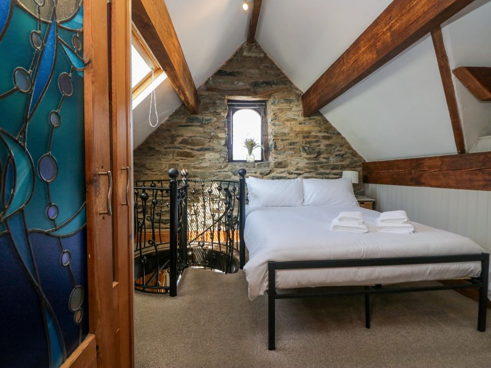 A bedroom with a bed and window at Hillside Cottage in Bowness-On-Windermere