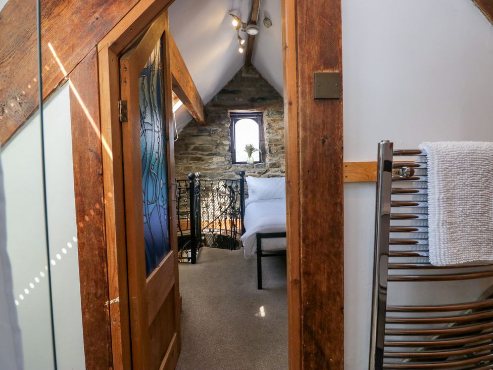 A bedroom with a staircase and a window at Hillside Cottage in Bowness-On-Windermere