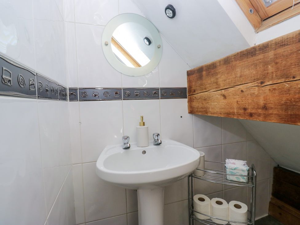 A bathroom with a sink, mirror, and towel holder at Hillside Cottage in Bowness-On-Windermere
