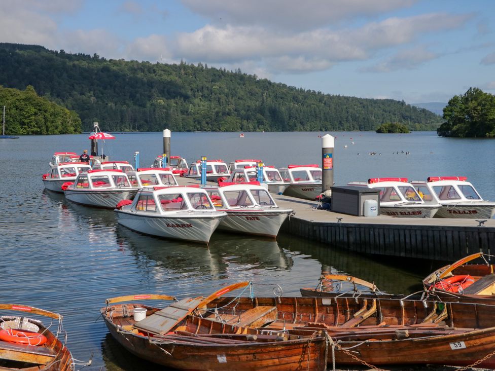 A collection of boats at a dock on a lake at Hillside Cottage in Bowness-On-Windermere