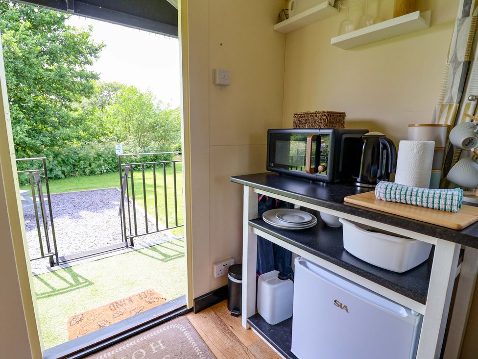 A kitchen with a microwave and kettle at Bee Happy in Whitchurch