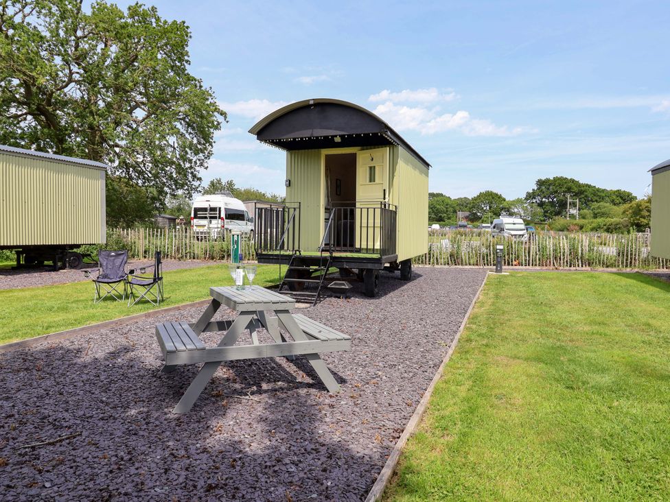 A shed with a table and chairs in the outdoor area at Bee Happy in Whitchurch