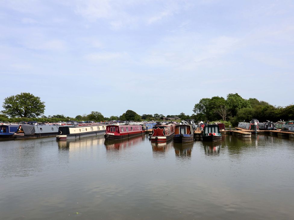 A group of narrowboats on water at Bee Happy in Whitchurch