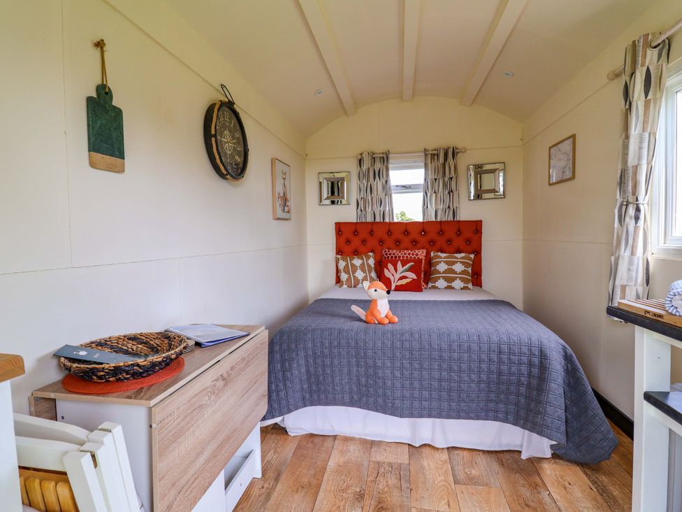 A bedroom with a bed and decorative items at Foxes Den in Whitchurch
