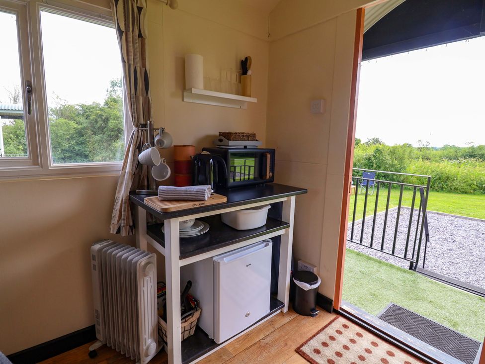 A kitchen with a window and a door leading outside at Foxes Den in Whitchurch