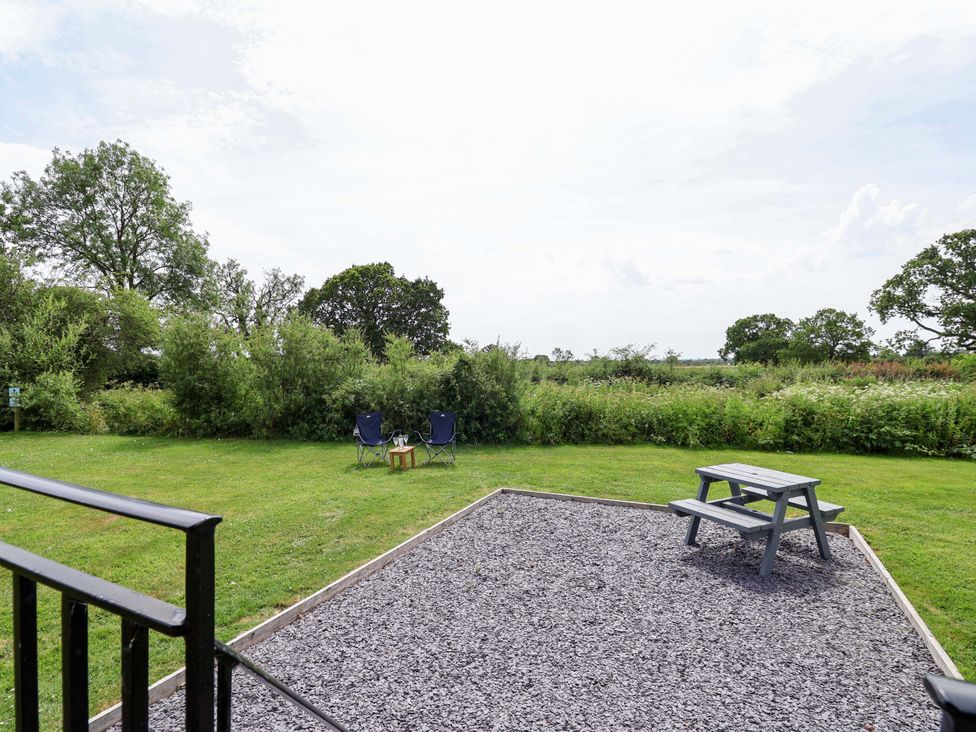 A garden with chairs and a table at Foxes Den in Whitchurch