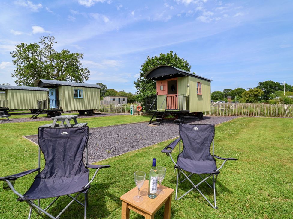 An outdoor area with chairs and a table near wagons at Foxes Den in Whitchurch