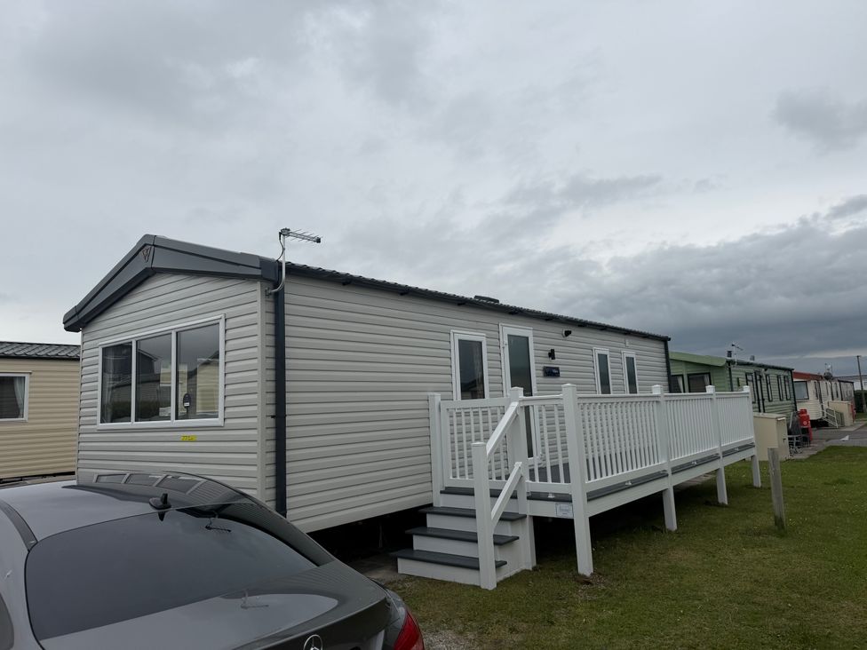 A mobile home with a white railing and steps at Trecco bay holiday park- Magnolia 11 Porthcawl