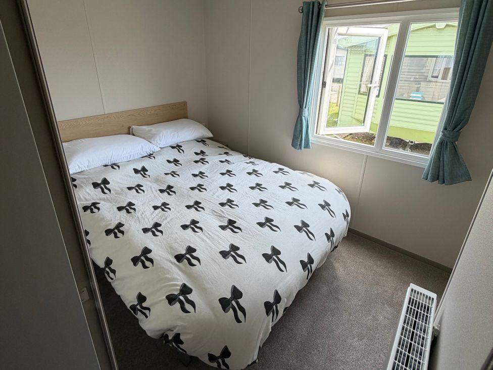 A bedroom with a double bed and a window at Trecco Bay Holiday Park - Magnolia 11 Porthcawl