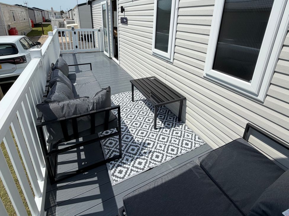A patio area with a sofa and table at Trecco bay holiday park- Magnolia 11, Porthcawl