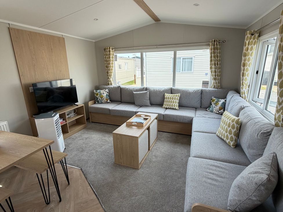 A living room with a sofa and television at Trecco bay holiday park- Magnolia 11 Porthcawl