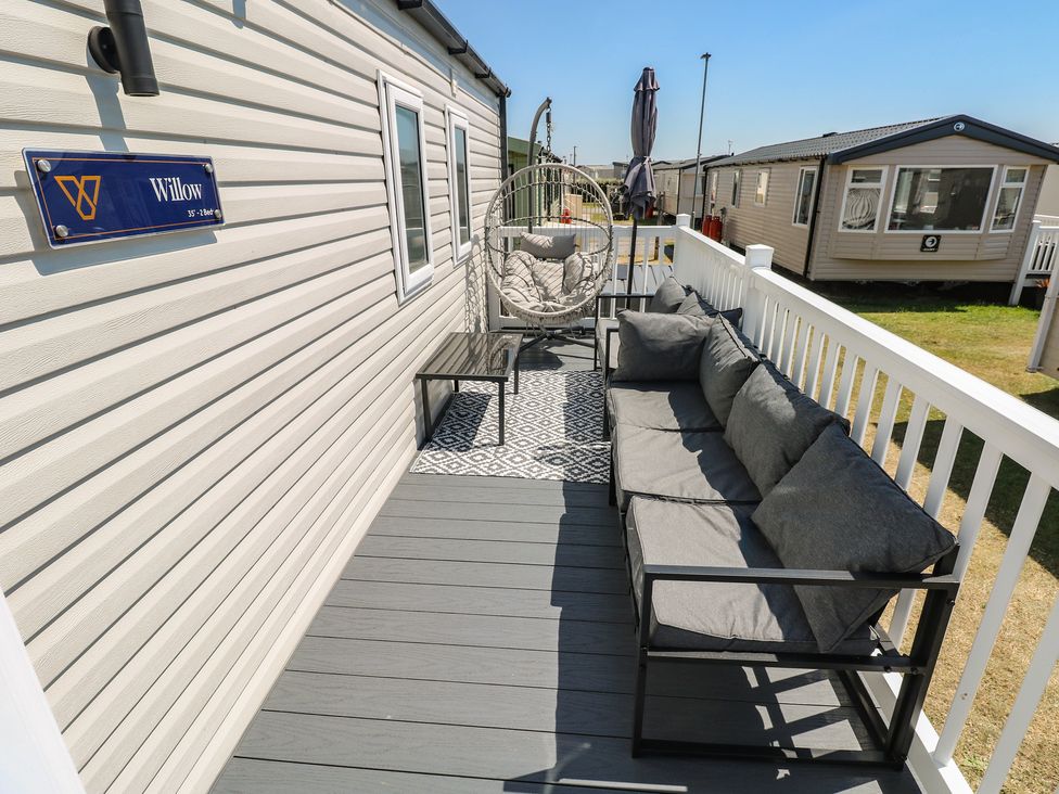 An outdoor space with a sofa and hanging chair at Trecco Bay Holiday Park - Magnolia 11 in Porthcawl