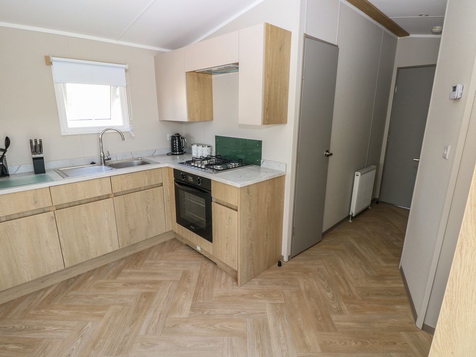 A kitchen with a sink and stove at Trecco Bay Holiday Park - Magnolia 11 Porthcawl