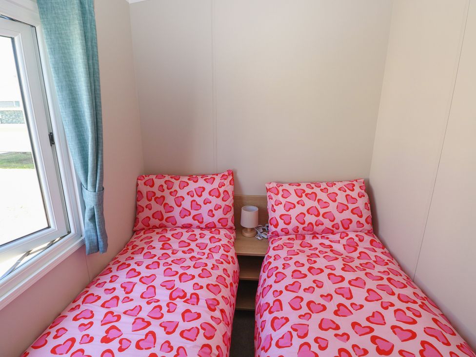 A bedroom with two beds and a lamp at Trecco Bay Holiday Park - Magnolia 11, Porthcawl