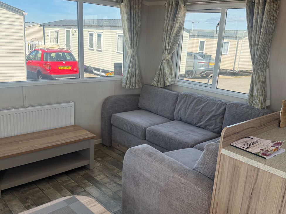 A living room with a sofa and coffee table at Trecco Bay in Porthcawl