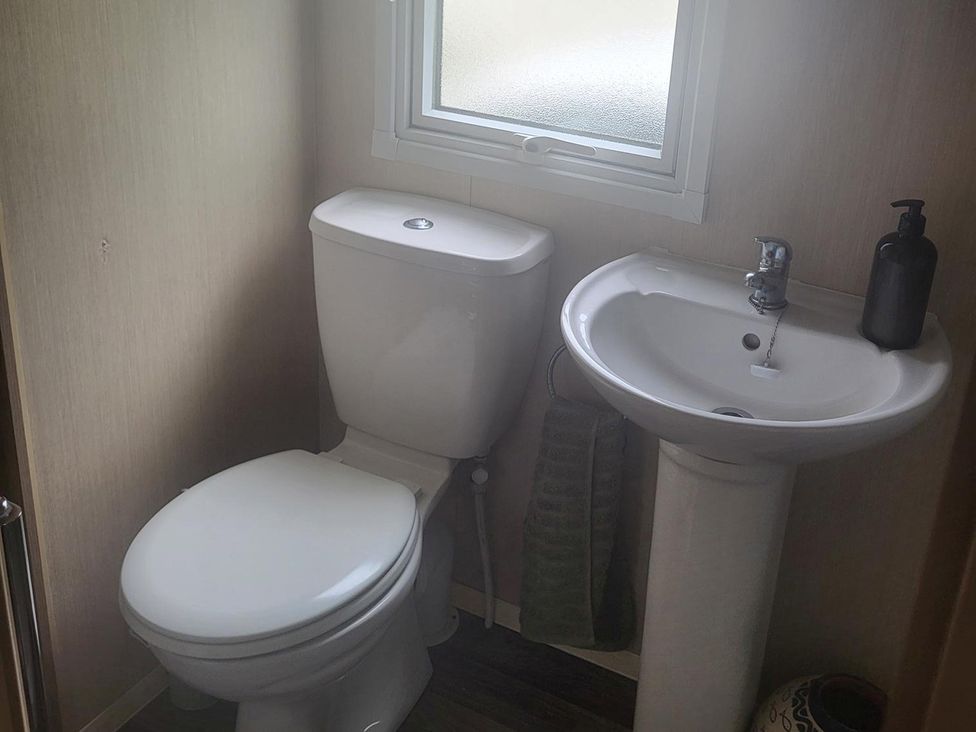 A bathroom with a toilet and sink at 164 Broadland Sands Holiday Park in Lowestoft