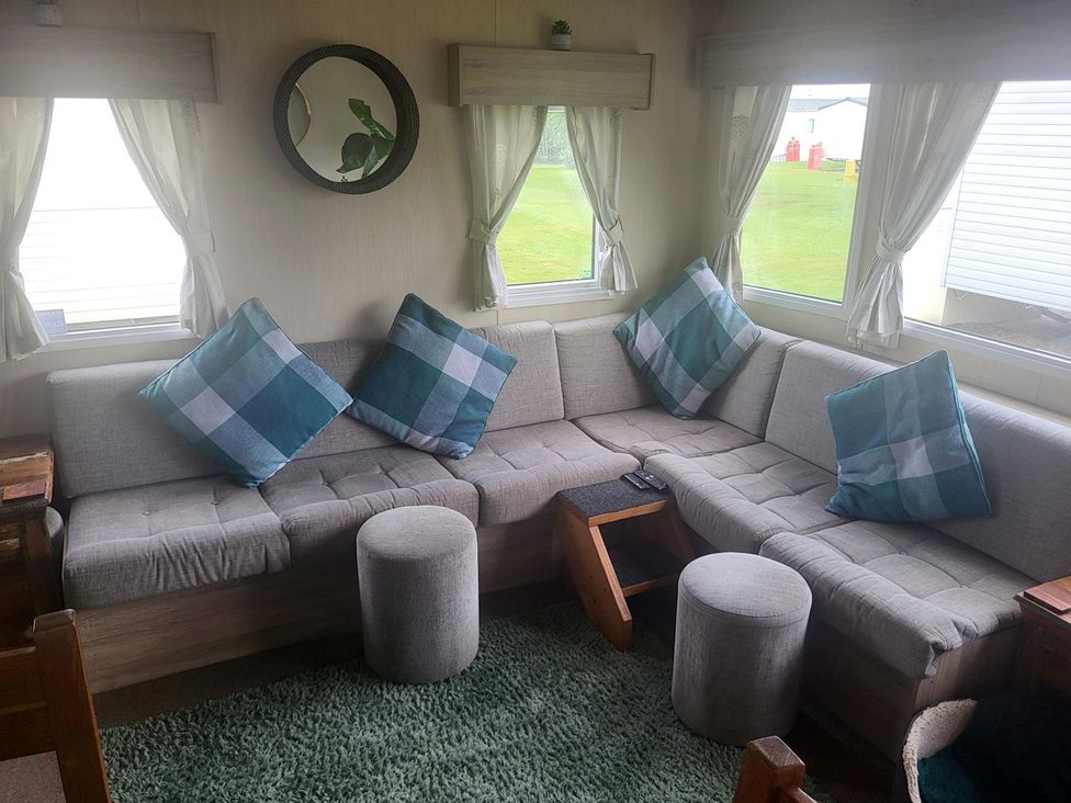 A living room with a sofa and cushions at 164 Broadland Sands Holiday Park in Lowestoft