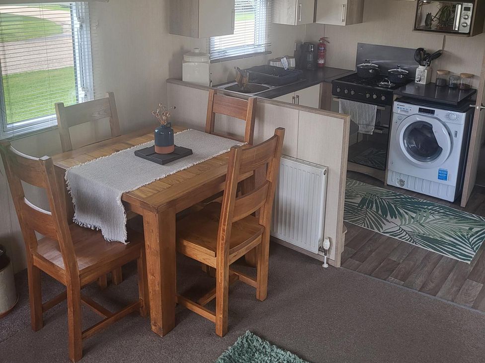 A kitchen with a table and chairs at 164 Broadland Sands Holiday Park in Lowestoft