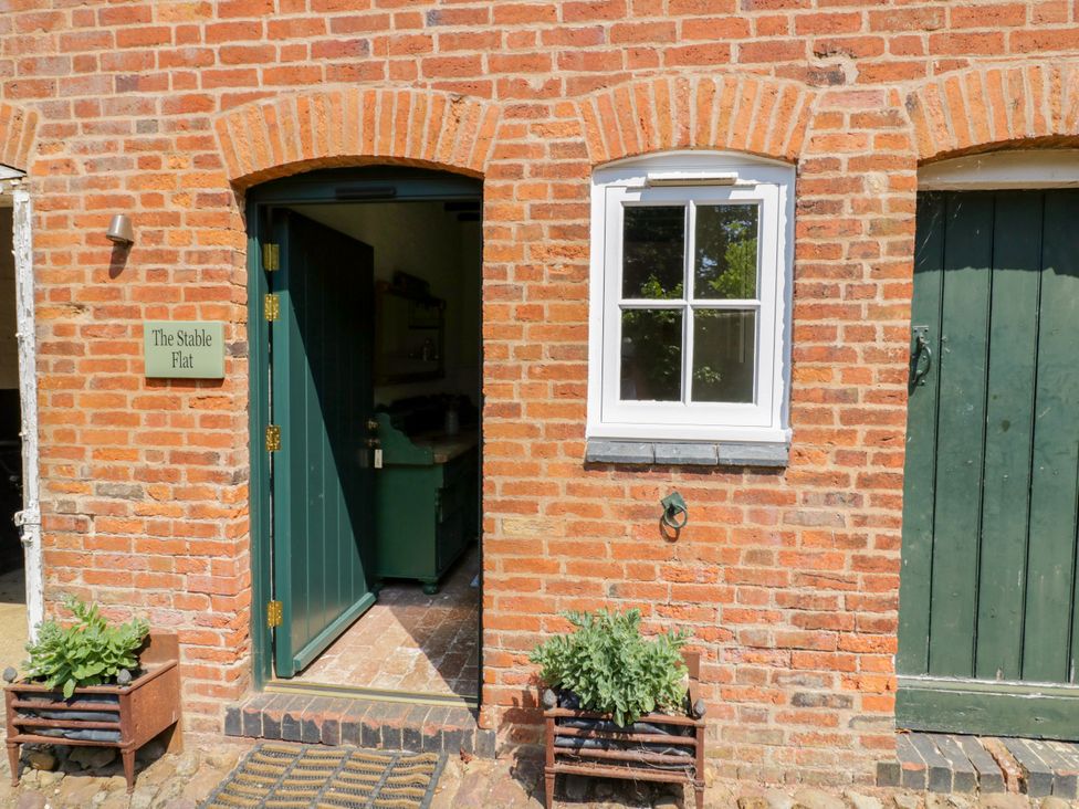 An entrance with a green door and sign at The Stable Flat 