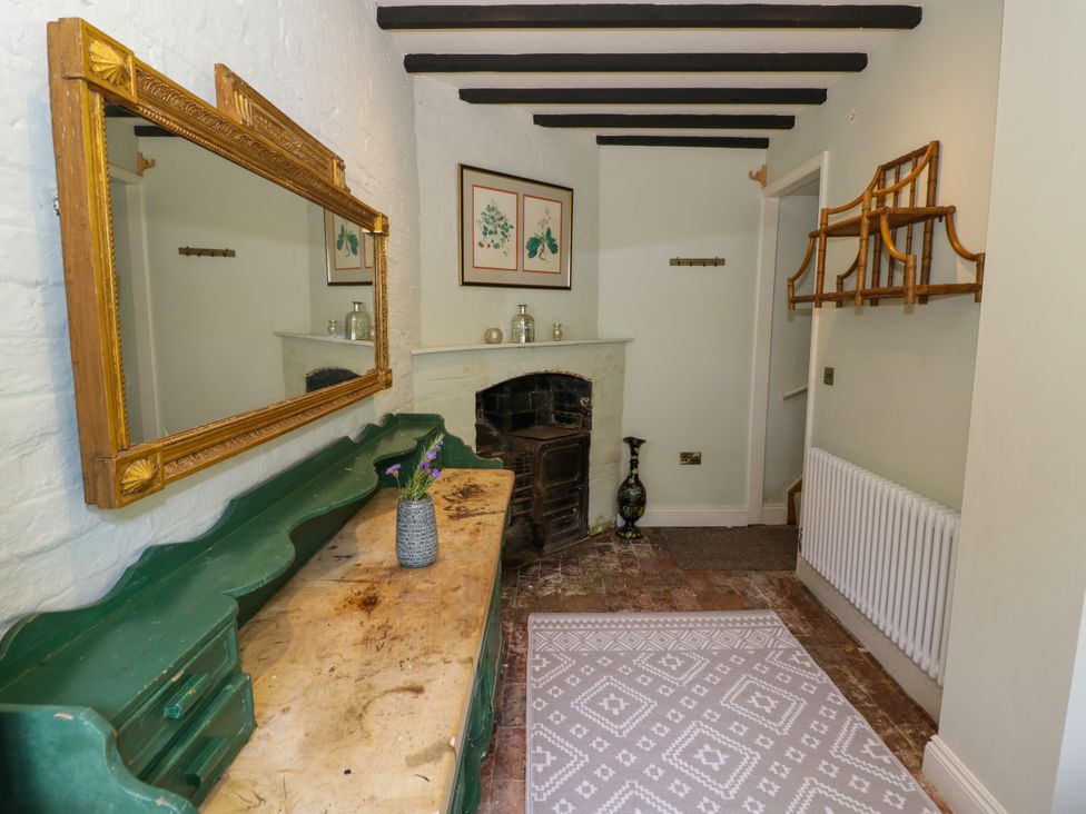 A hallway with a mirror and fireplace at The Stable Flat