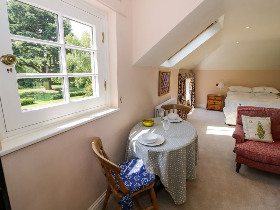 A bedroom with a table and chairs at The Stable Flat 