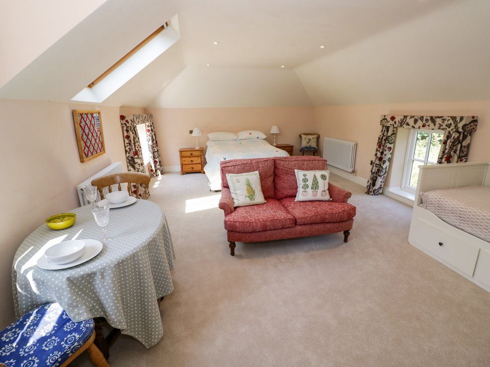 A bedroom with a bed and a dining area at The Stable Flat