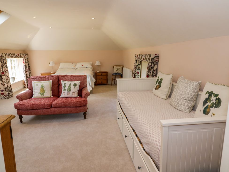 A bedroom with a bed and seating area at The Stable Flat 
