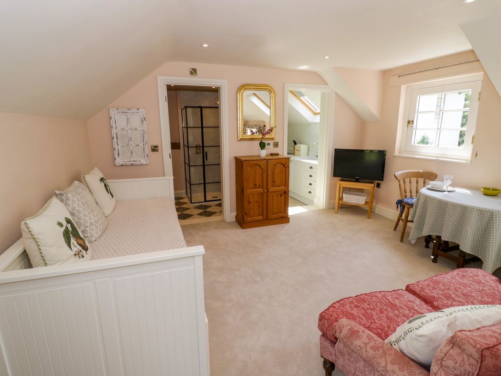 A living room with a sofa and television at The Stable Flat in 