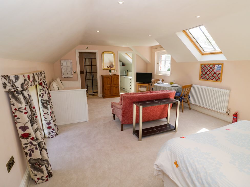 A bedroom with a bed, sofa, and table at The Stable Flat in 