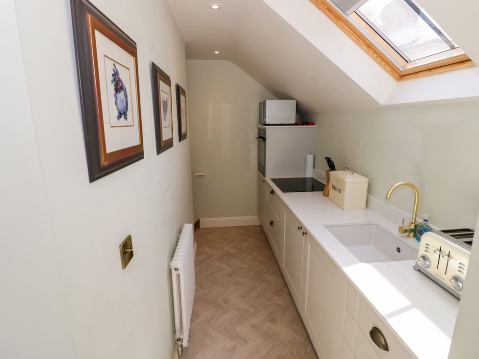 A kitchen with framed pictures and appliances at The Stable Flat 
