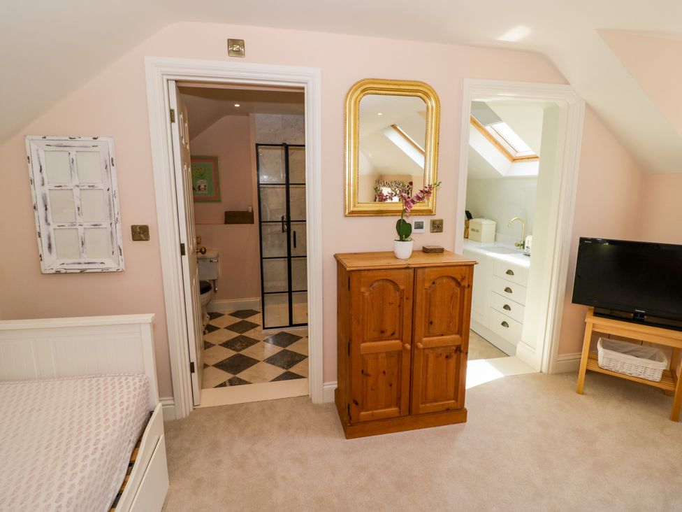 A bedroom with a dresser and bathroom door at The Stable Flat in 