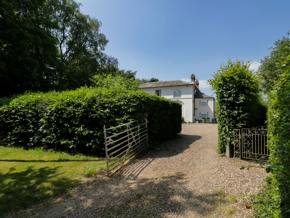 A house with hedges and a gravel driveway at The Stable Flat