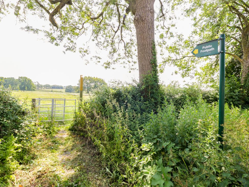 A path leading through a gate with a sign indicating a public footpath at The Stable Flat